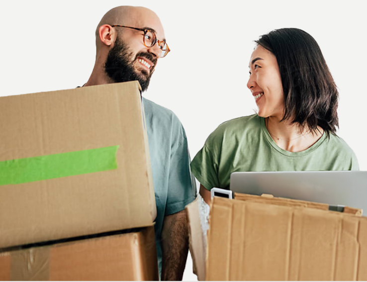 mand and woman smiling with boxes of electronics to recycle